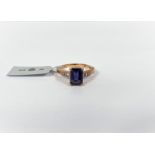 A rectangular blue Bengal lolite dress ring with clear tanzanites to each shoulder, in 9k gold