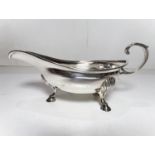 A small hallmarked silver sauce boat with C scroll handle and three hoof feet. London 1802, 3.8oz