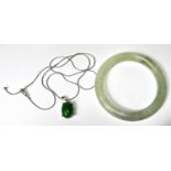 A silver necklace with jade coloured hardstone cabochon; A Chinese Jade coloured hardstone bangle