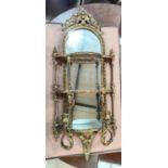 A 19th century gilded 3 tier mirror backed whatnot with twin sconce and ornate crest