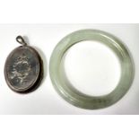 A late 19th century locket with incised decoration to the front and back; a Chinese jade coloured