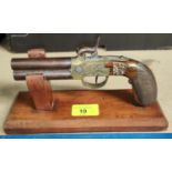 An early 19th century percussion cap muff pistol on stand, with 'under-over' double barrel;
