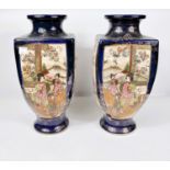 An early 20th century pair of Japanese satsuma vases of square baluster form, with reserve panels of