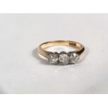 A yellow metal dress ring stamped '18ct', set 3 diamonds, central stone diameter 4mm approx, size '