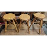 Four modern light wood circular stools on four legs