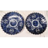 A pair of blue and white oriental wall plaques with shaped boarders and plant decoration, dia 31cm