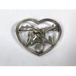 Georg Jensen:  a heart shaped openwork brooch with a pair of dolphins and strand above shell,