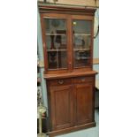 A mahogany full height bookcase with double glazed doors above, two drawers and double cupboards