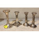 Four hall marked silver candle sticks with weighted bases, a pair and two single sticks one with
