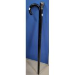 An ebonised walking cane with silver top (top a.f.); a similar cane