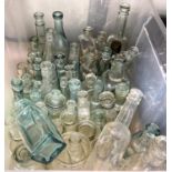 A collection of vintage glass bottles various colours and shapes some with advertising lettering