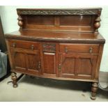 A 1930's oak period style sideboard with raised back, 2 cupboards and 2 drawers