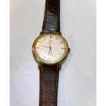 A mid 20th century Omega wristwatch with baton numerals and a brown leather strap