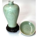 A Chinese celadon column vase with relief face mask decoration, six character mark to base, hardwood