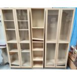 A modern pale wood effect pair of book cases/ display cases with full height glazed doors and a