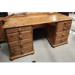 A pine twin pedestal desk with four drawers to each side, depth 45cm, length 145cm and height 74cm