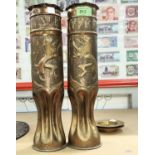 A pair of WWII period trench art shells in the form of vases with pinched bases, embossed lion