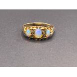 An 18ct hallmarked gold gypsy style ring set with 3 opal coloured stones and diamond chips, 3.4gm,