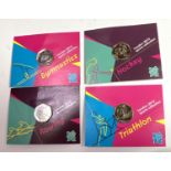 Four 2012 Olympic 50p coins in Royal Mint packs: gymnastics, hockey, triathlon and rowing.