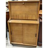 A mid 20th century teak hinge lidded bedding box and a mid 20th century light wood bureau with