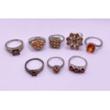 8 silver rings stamped '925' with orange coloured stones in a variety of settings gross weight