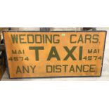 A vintage advertising sign with hand painted lettering, Taxi, Wedding Cars, framed and backed on old
