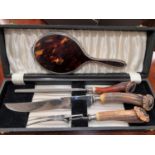 A cased Horn handle three piece carving set; a hall mark silver and tortoise shell backed hand