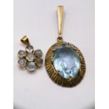 A yellow metal pendant stamped 14k set with 7 moonstone type stones in flowerhead design; an oval