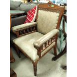 An oak framed arm chair with carved detail studded sage coloured leather effect over stuffed