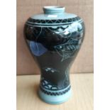 A modern oriental inverted baluster vase decorated with fish in dark blue against a light blue