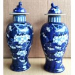 A pair of modern Chinese inverted baluster covered vases decorated in underglaze, blue and white