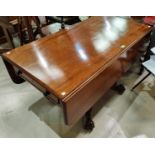 An early 19th century mahogany Pembroke dining table with twin frieze drawers, turned ringed column,