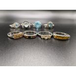 4 silver rings stamped '925' each set with aquamarine coloured stones in a variety of settings; 4