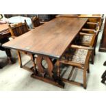 An oak refectory dining table with harp shaped supports, stretcher, with four carver chairs with
