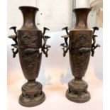 A 19th century Japanese pair of bonze vases with relief decoration and naturalistic handles,