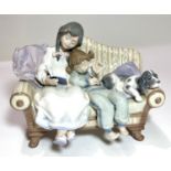 A Lladro group:  boy, girl and dog on a couch