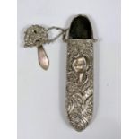 A hall marked silver spectacles case with embossed scrolling floral decoration, with chain and hook,