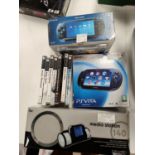 A Sony PlayStation Portable boxed with a selection of games and a docking station, and a boxed PS