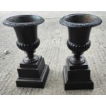A pair of cast iron urns in the Victorian classical style, on square detachable bases, height 65cm