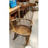 A stained wood rocking chair with stick back