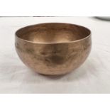 A brass Tibetan singing bowl with circular etching to interior and hammered decoration to body 18.