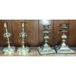 An unusual pair of brass French style candlesticks and a similar pair of squared classical style