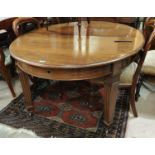 A late 19th/early 20th century mahogany dining table with oval wind out top on square tapering