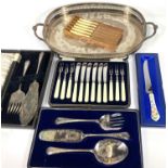 A cased set of dessert knives and forks; cased serving sets; a silver on copper gallery tray; a