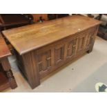 An oak reproduction blanket box with carved panels