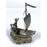 A hallmarked silver model:  man in a single masted boat, import marks for Chester 1891, height 11cm