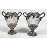 A Continental pair of cut glass vases, ovoid ribbed form with extensive cast white metal mounts on