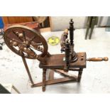 A late 19th/early 20th century wooden spinning wheel with foot pedal etc