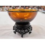 A Chinese Peking amber glass bowl etched four character signature to base and associated hardwood