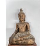A South East Asian carved wooden seated Buddha decorated in gilt with wooden base height 20cm